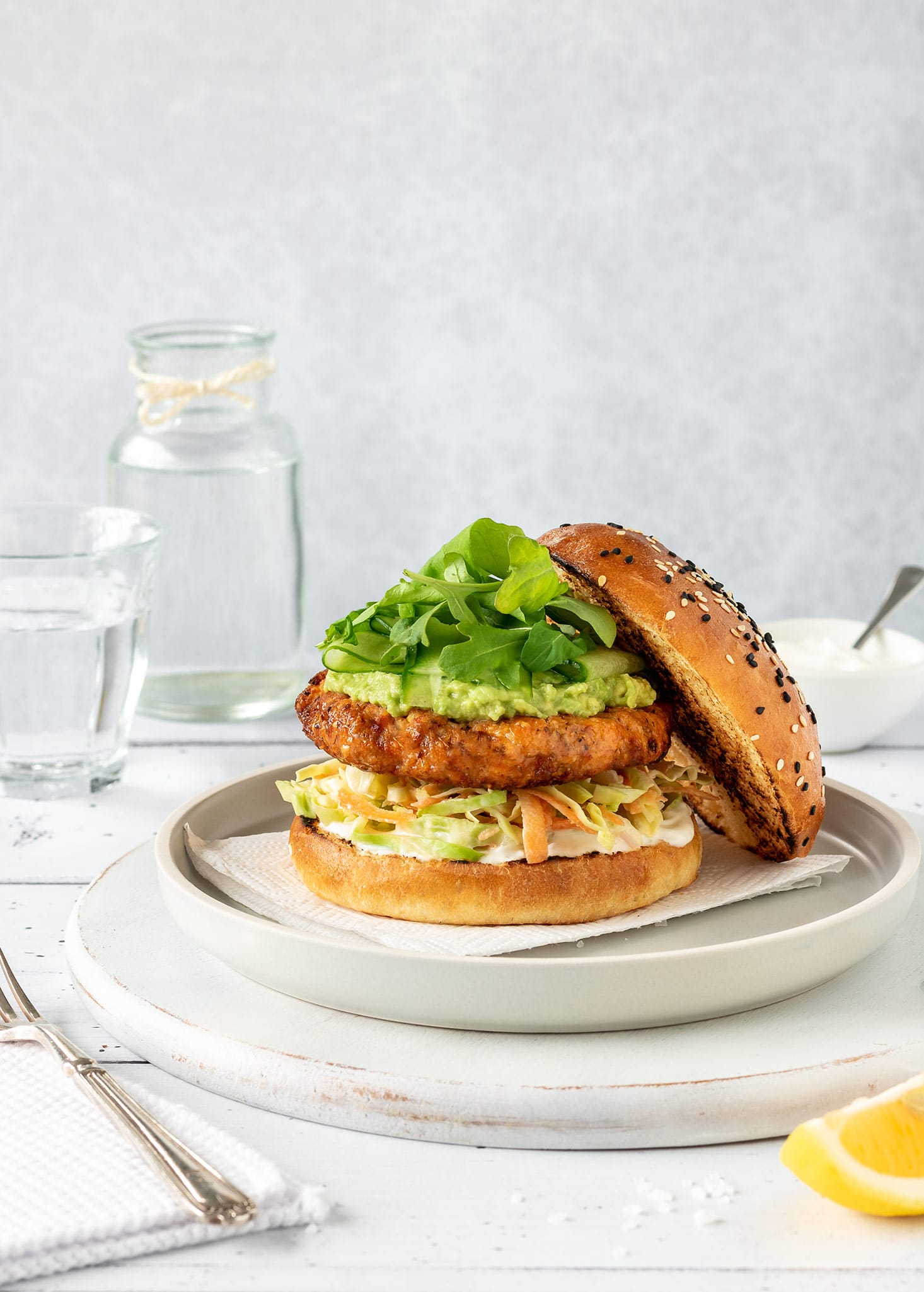 Salmon burger with salmon patty, slaw, avocado and rocket.