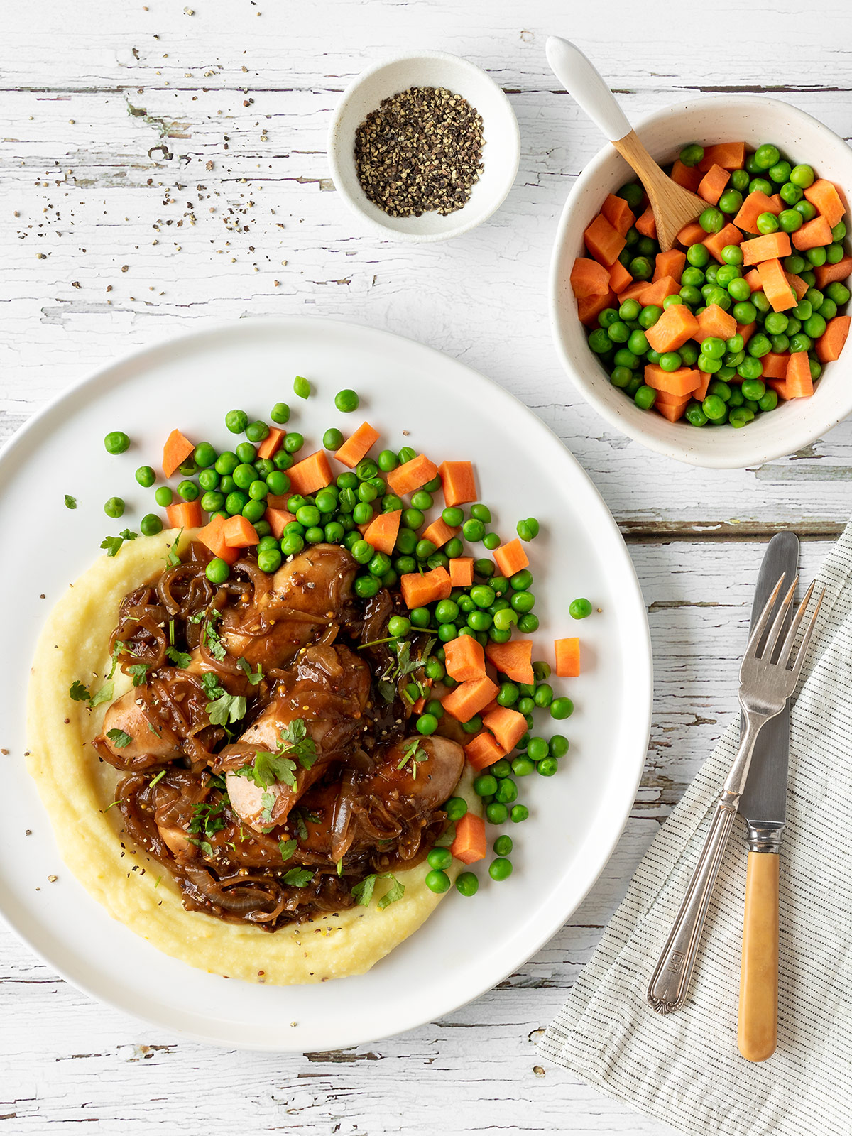 Bangers and mash with onion gravy, peas and carrots.