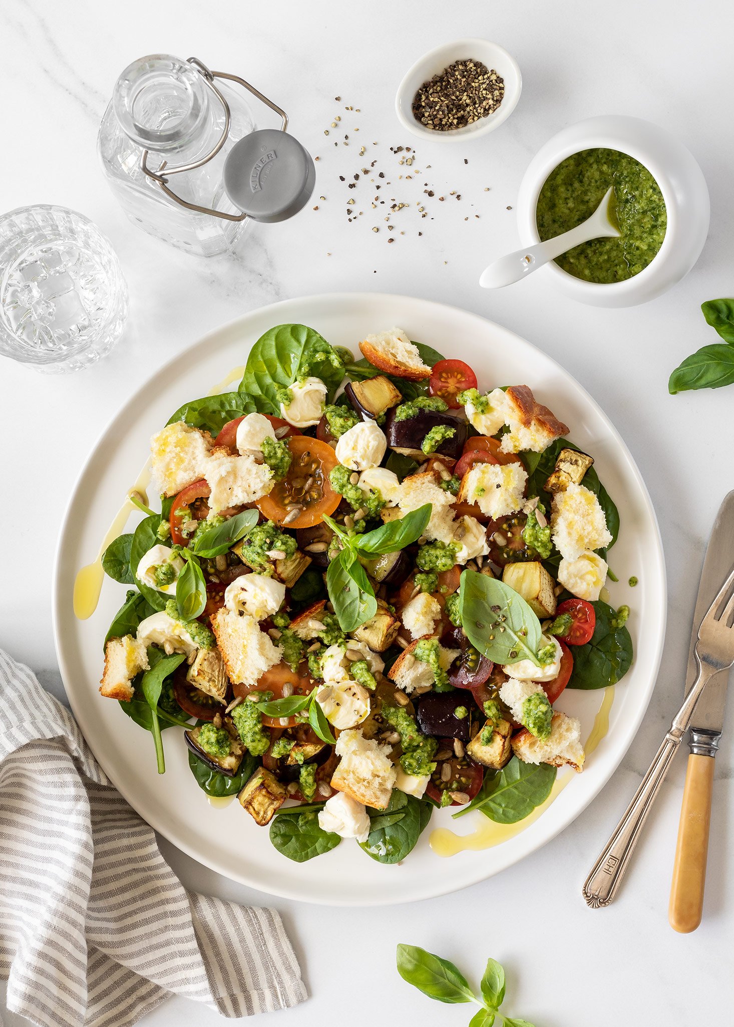 Loaded caprese salad with roasted eggplant, croutons and basil pesto dressing.