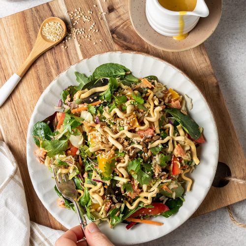Café-style mango salmon salad with crispy noodles and soy toasted seeds.