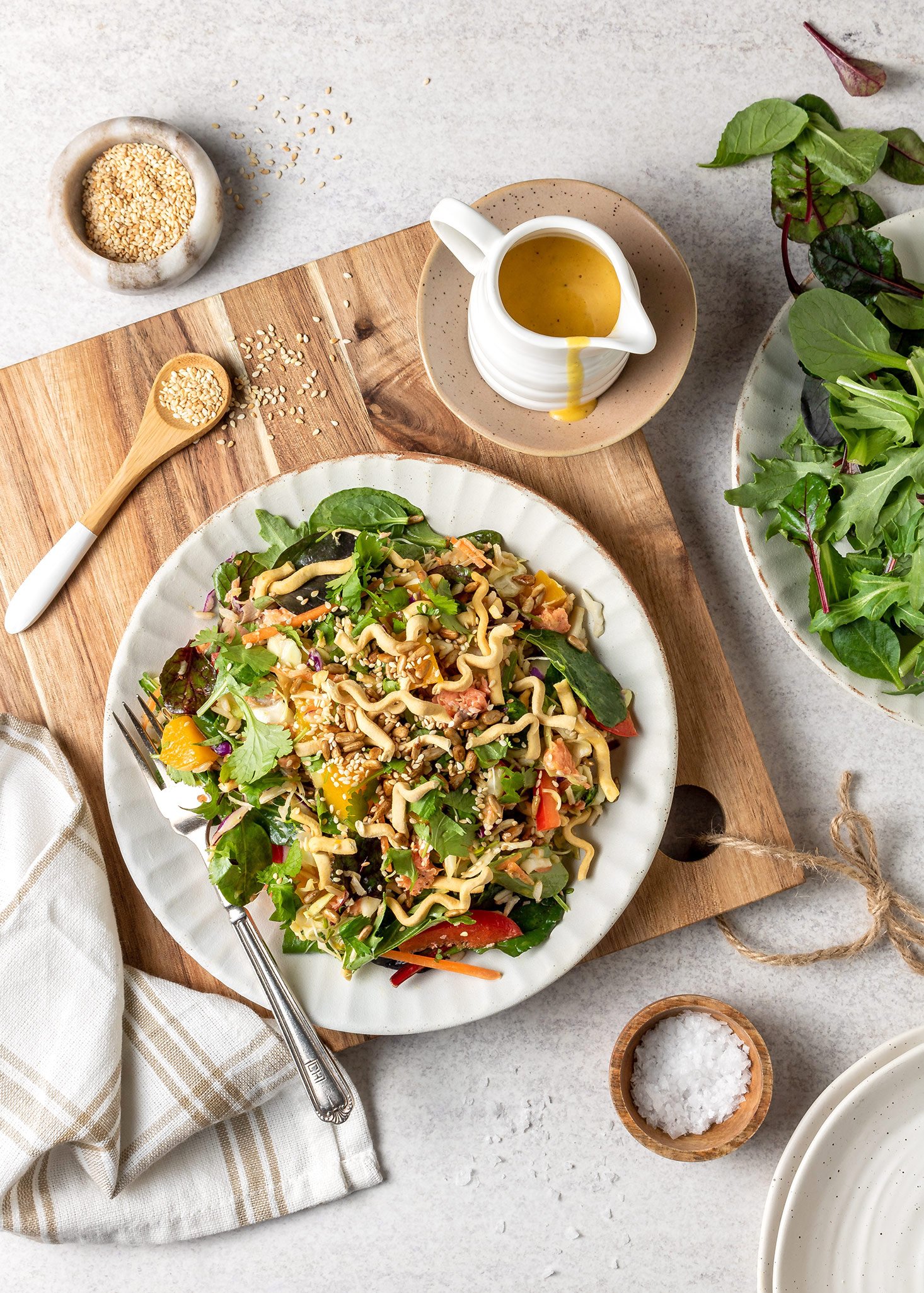Café-style mango salmon salad with crispy noodles and soy toasted seeds.